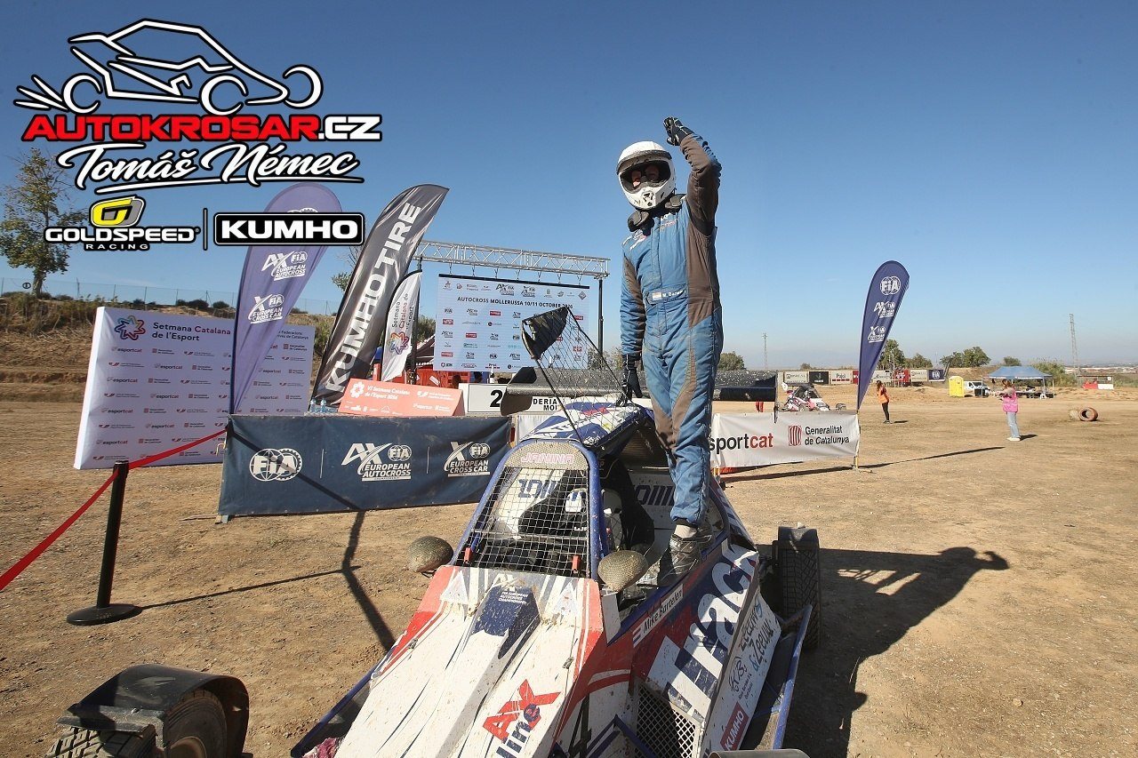 La celebrazione accanto al buggy, con il pubblico e i cartelli del circuito sullo sfondo.
